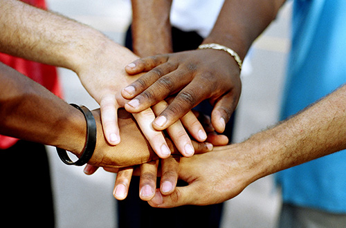 Community members joining hands together